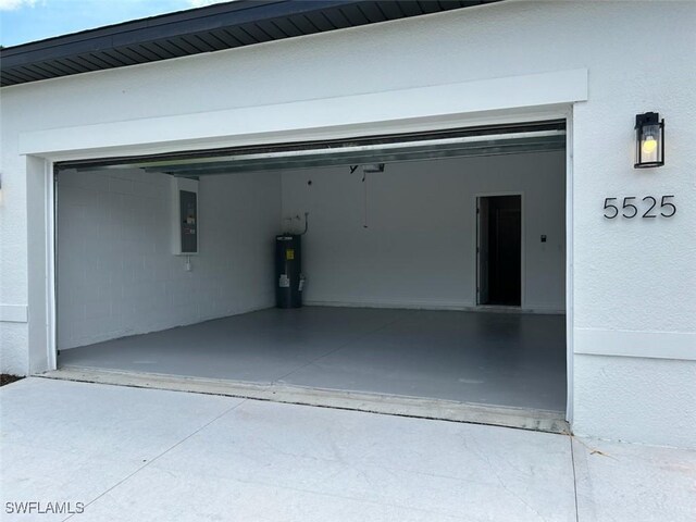 5525 Berryman St, Lehigh Acres, FL 33971 - garage featuring concrete driveway, electric panel, and electric water heater