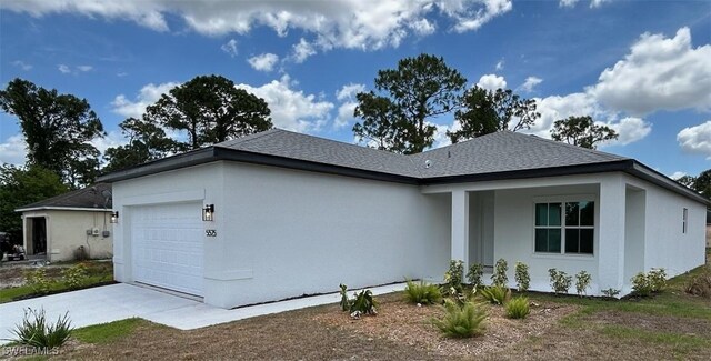 5525 Berryman St, Lehigh Acres, FL 33971 - view of property exterior featuring an attached garage, driveway, a shingled roof, and stucco siding