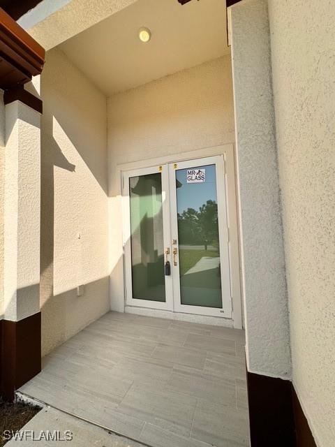 entrance to property with stucco siding and french doors