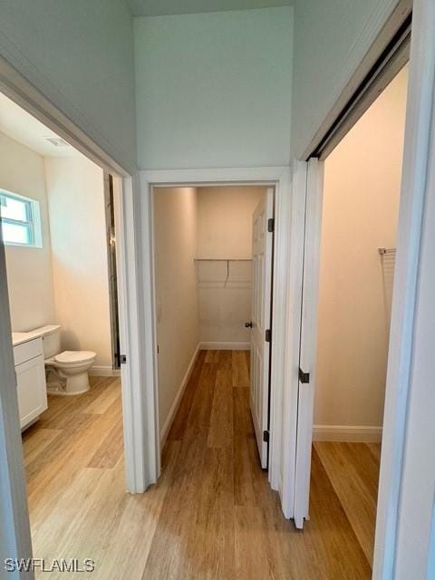 hall featuring baseboards and light wood-style floors