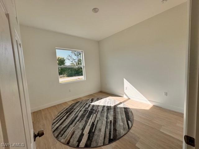 unfurnished bedroom with baseboards and light wood-style floors