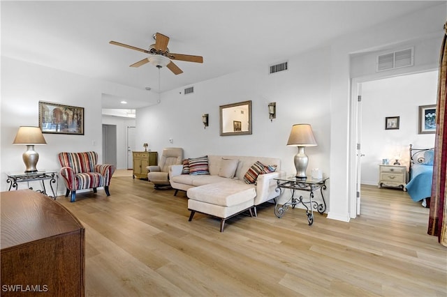 living room featuring visible vents, a ceiling fan, and light wood-type flooring