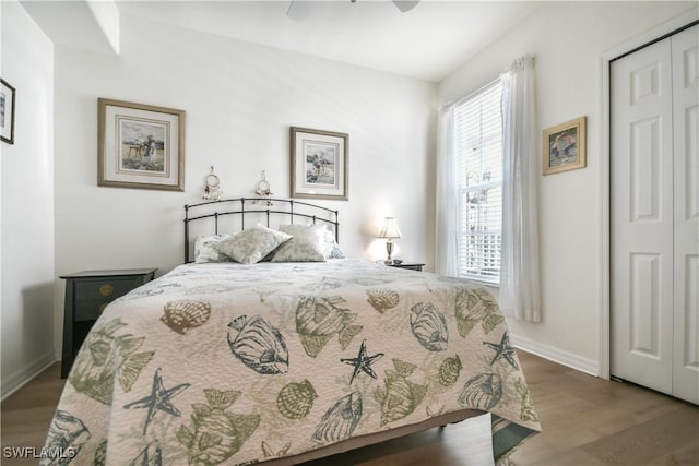 bedroom featuring a ceiling fan, baseboards, wood finished floors, and a closet