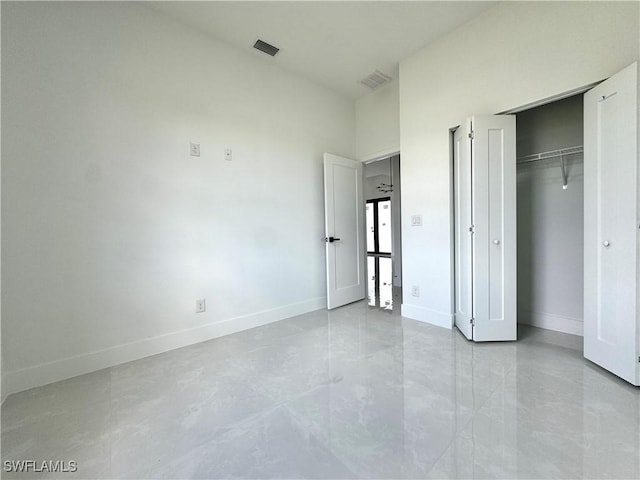unfurnished bedroom with baseboards, a closet, and visible vents