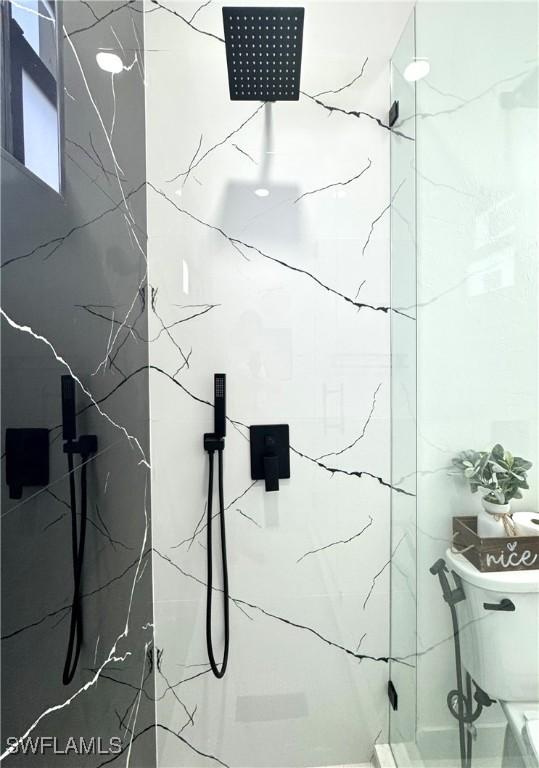 bathroom with a marble finish shower