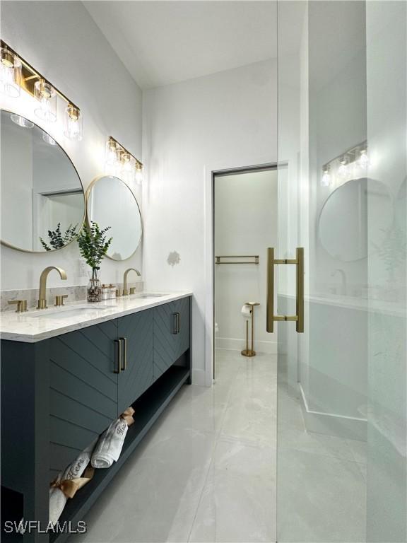bathroom with a sink, double vanity, and marble finish floor