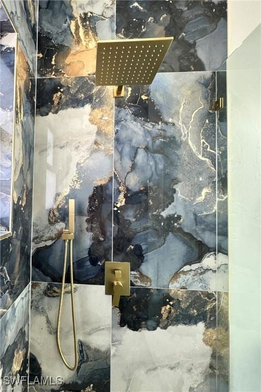 interior details featuring a marble finish shower
