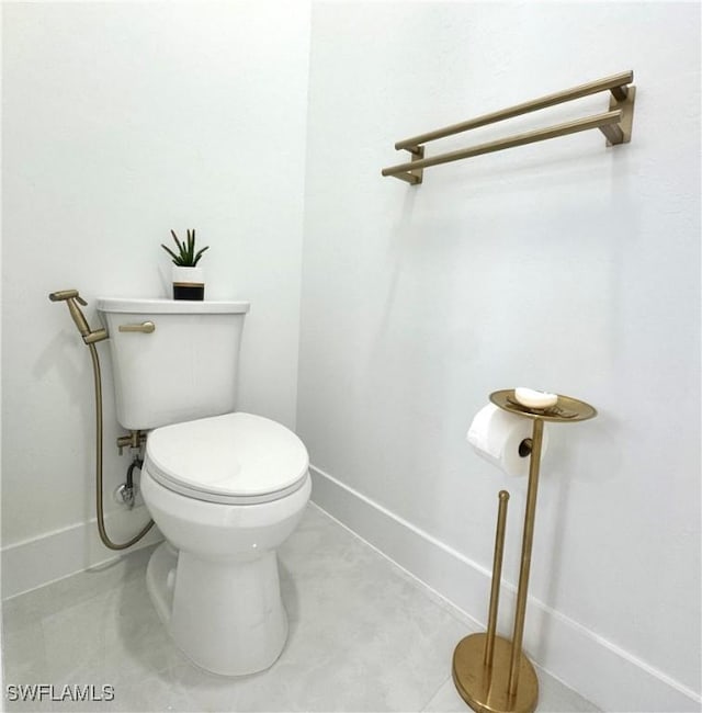 bathroom with baseboards and toilet