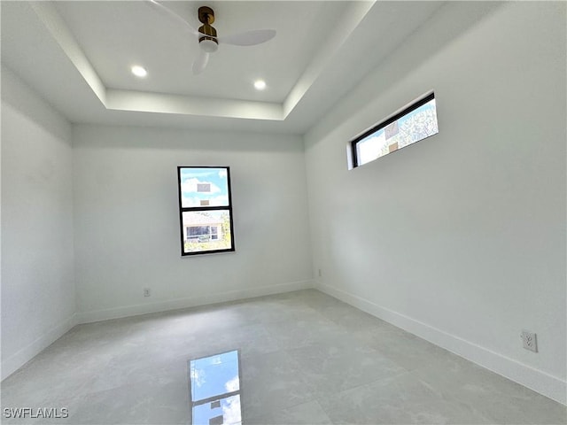 unfurnished room featuring baseboards, recessed lighting, a raised ceiling, and ceiling fan
