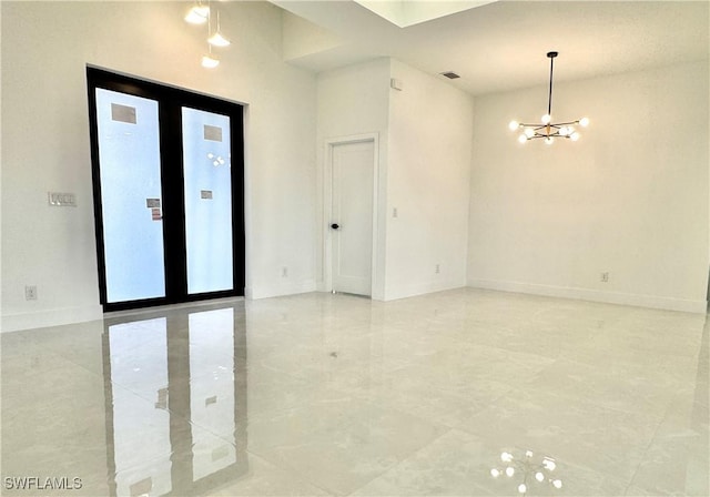 empty room with baseboards, an inviting chandelier, and visible vents