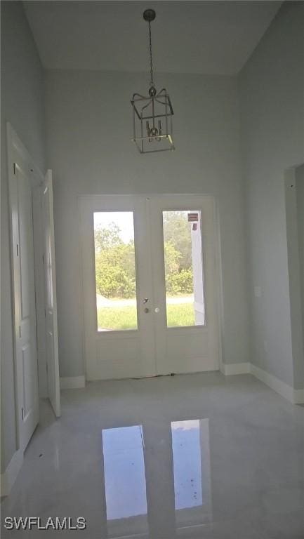 doorway with french doors, finished concrete flooring, and baseboards