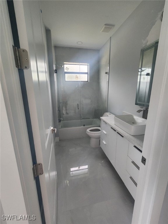 bathroom featuring visible vents, vanity, marble finish floor, shower / bath combination with glass door, and toilet