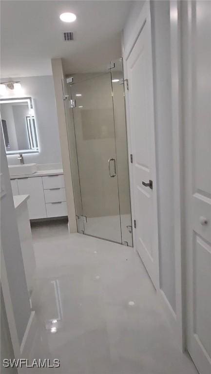 bathroom with vanity, a shower stall, recessed lighting, and visible vents