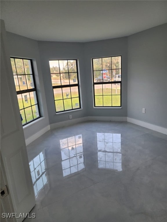 empty room with baseboards and concrete floors