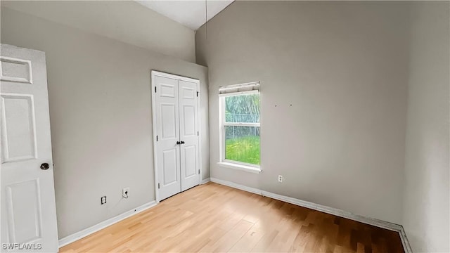 17942 Oakmont Ridge Cir, Fort Myers, FL 33967 - unfurnished bedroom featuring light wood-style flooring, baseboards, a closet, attic access, and vaulted ceiling