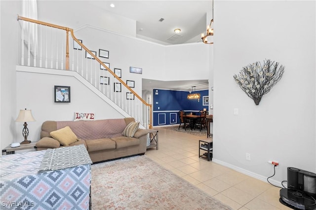 tiled living room featuring stairway, baseboards, a high ceiling, and a notable chandelier
