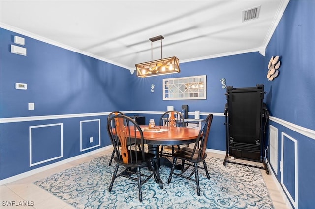 dining space featuring wainscoting, ornamental molding, and visible vents