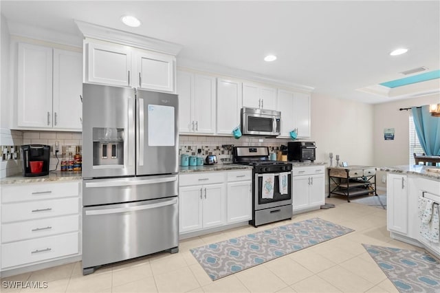 kitchen featuring stainless steel appliances, decorative backsplash, visible vents, and white cabinets