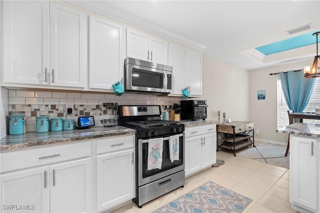 kitchen with stainless steel appliances, tasteful backsplash, visible vents, and white cabinets