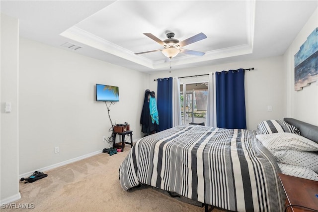 carpeted bedroom with crown molding, visible vents, baseboards, and a raised ceiling