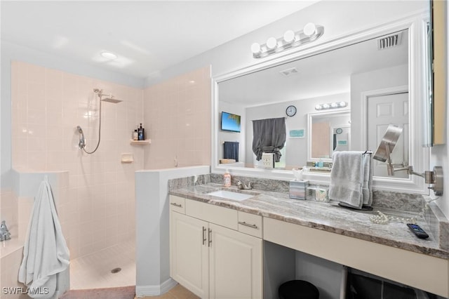 bathroom with vanity, visible vents, and a walk in shower