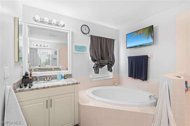 full bath with a garden tub and vanity