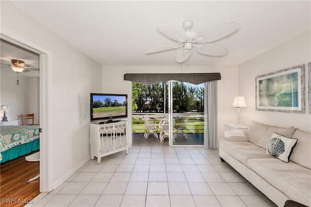 living room with light tile patterned floors, baseboards, and a ceiling fan