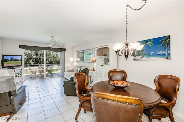 dining space with light tile patterned flooring and ceiling fan with notable chandelier