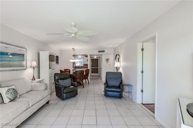 living room featuring a ceiling fan, baseboards, visible vents, and light tile patterned floors