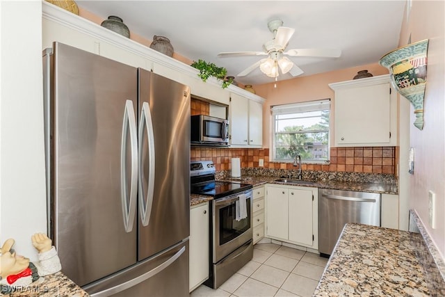 kitchen featuring a sink, appliances with stainless steel finishes, backsplash, and light tile patterned floors
