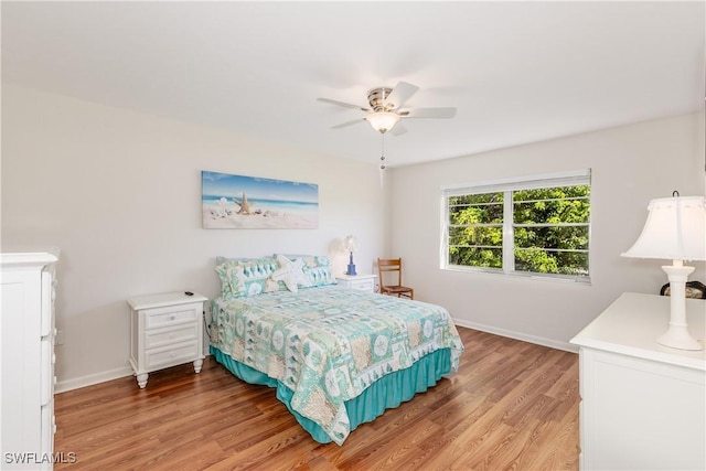 bedroom featuring baseboards, a ceiling fan, and light wood finished floors