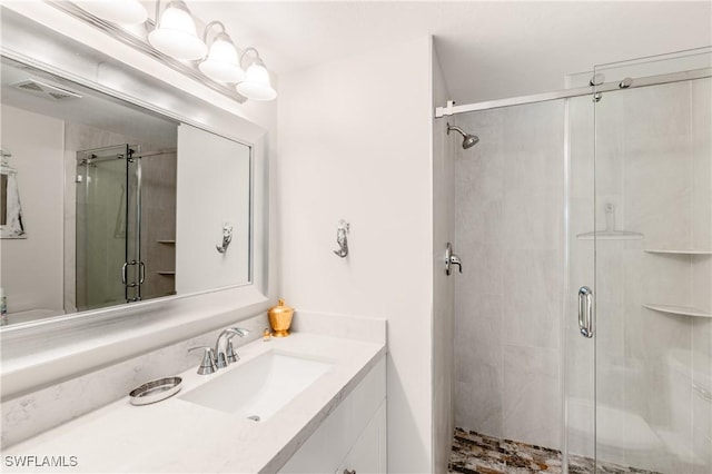full bathroom with visible vents, vanity, and a shower stall