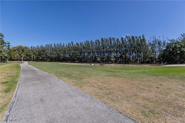 view of property's community with a yard and golf course view