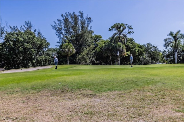 view of home's community featuring a lawn and view of golf course