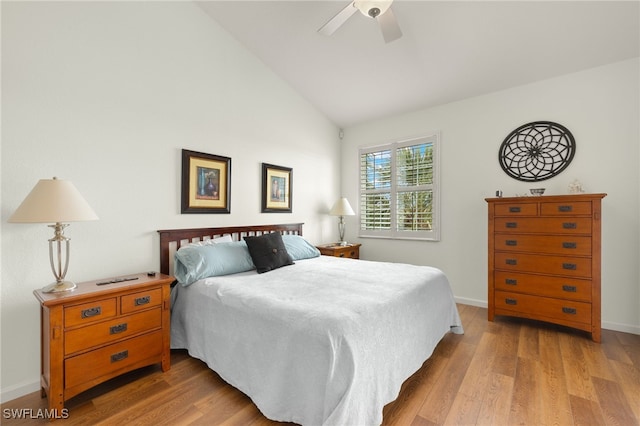 bedroom with light wood-style floors, baseboards, and lofted ceiling