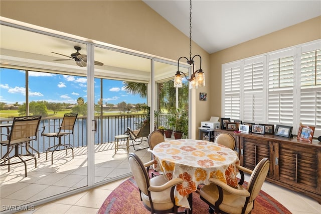 dining room with light tile patterned floors, a water view, a ceiling fan, and lofted ceiling