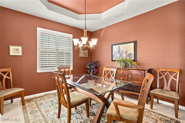dining space featuring light tile patterned flooring, an inviting chandelier, a raised ceiling, baseboards, and visible vents