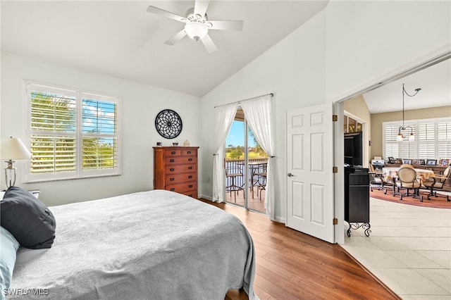 bedroom featuring high vaulted ceiling, access to exterior, wood finished floors, and ceiling fan with notable chandelier