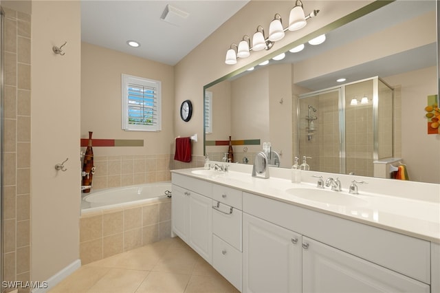bathroom featuring tile patterned flooring, a sink, a bath, and a stall shower