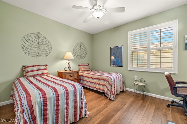bedroom with baseboards, a ceiling fan, and wood finished floors