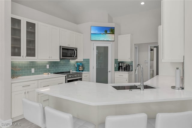 931 Snowberry Ct, Marco Island, FL 34145 - kitchen featuring a peninsula, appliances with stainless steel finishes, white cabinetry, and a sink