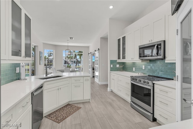 931 Snowberry Ct, Marco Island, FL 34145 - kitchen featuring light countertops, stainless steel appliances, a sink, and a peninsula