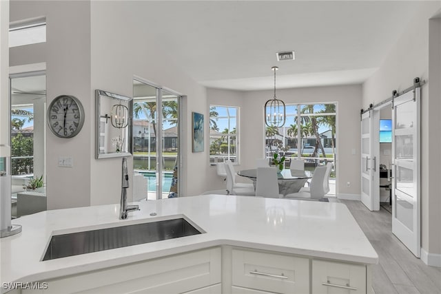 931 Snowberry Ct, Marco Island, FL 34145 - kitchen with a sink, a chandelier, white cabinetry, visible vents, and pendant lighting
