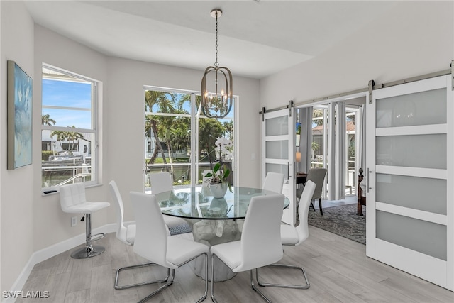 931 Snowberry Ct, Marco Island, FL 34145 - dining area with wood finished floors, baseboards, a barn door, and a chandelier