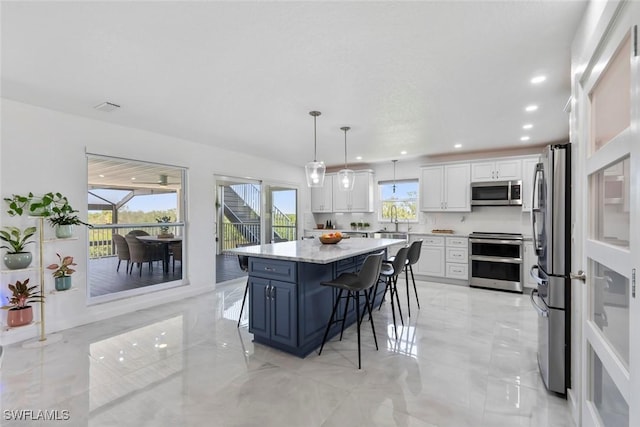 kitchen with a breakfast bar area, decorative light fixtures, white cabinets, stainless steel appliances, and recessed lighting