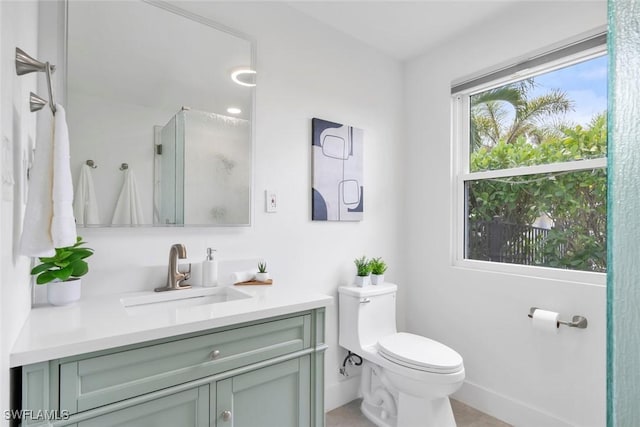 full bathroom featuring an enclosed shower, baseboards, vanity, and toilet