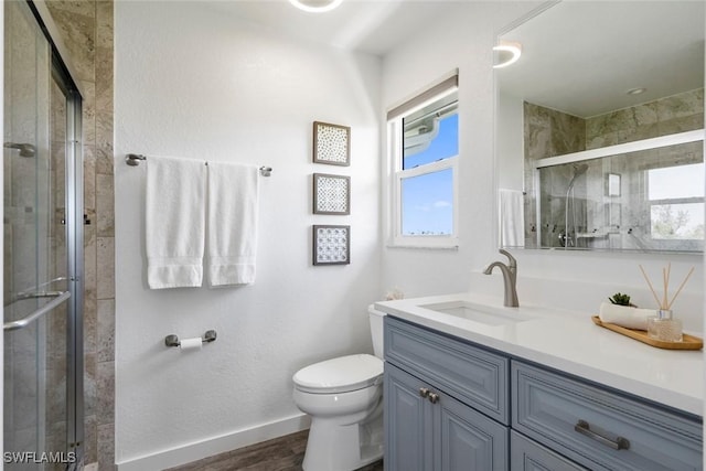 bathroom with vanity, a stall shower, a healthy amount of sunlight, and toilet