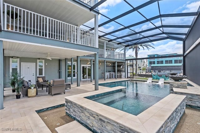 view of swimming pool featuring a patio, ceiling fan, outdoor lounge area, and glass enclosure
