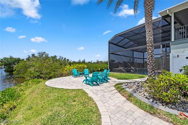 view of yard featuring a lanai, a patio, and a water view
