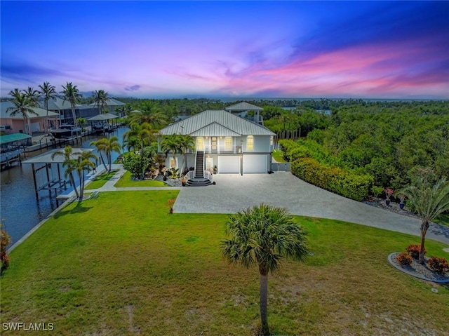 view of front of house featuring a water view, driveway, a front yard, and stucco siding